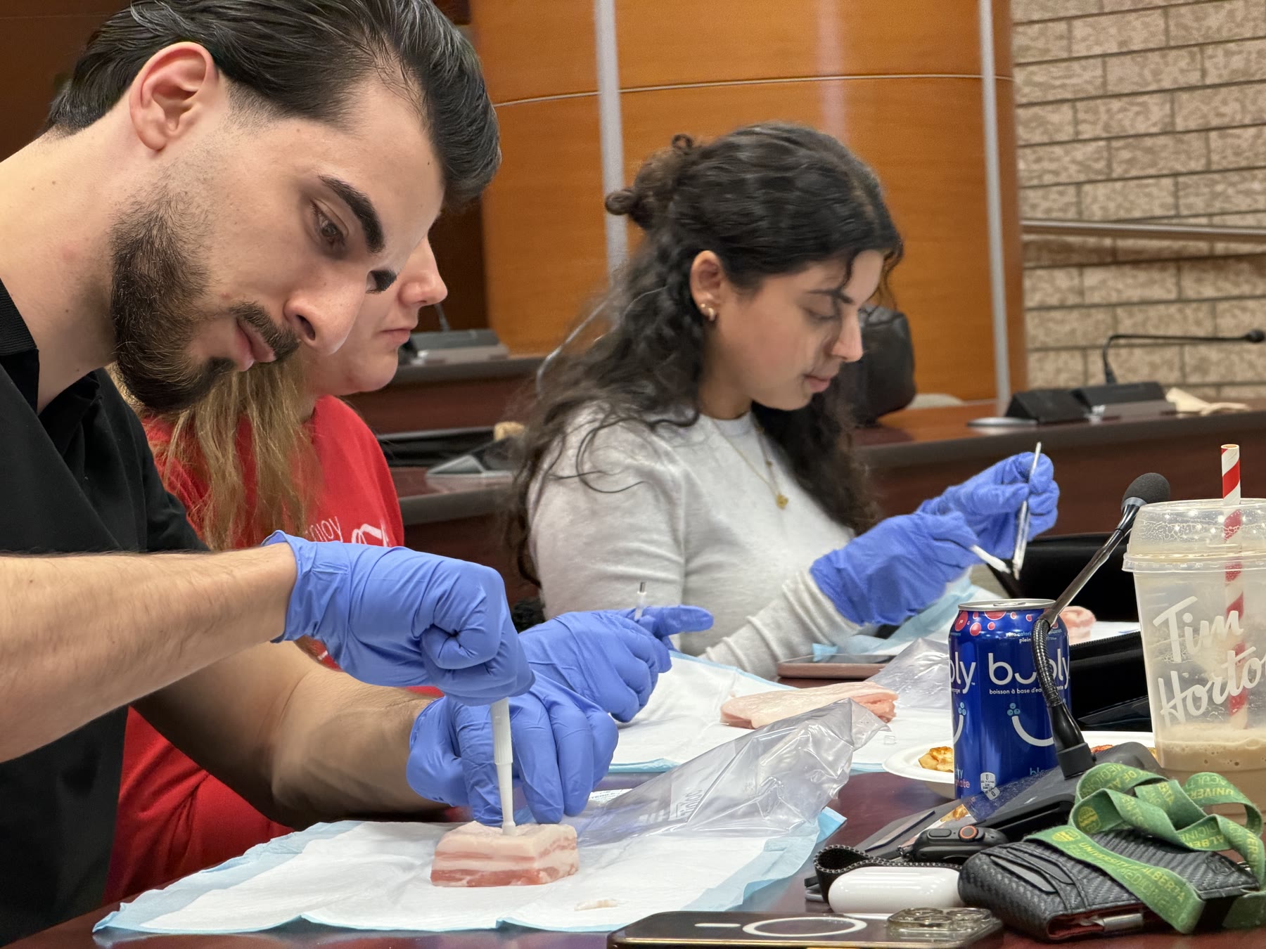 Medical trainees practising biopsy techniques on tissue models